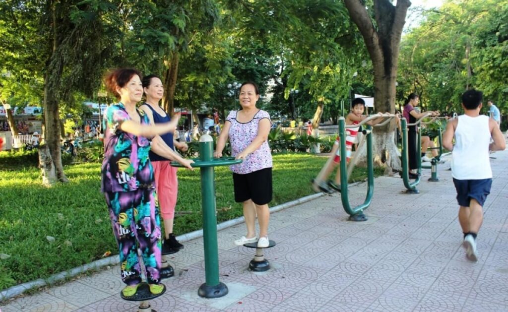 Vietnam Morning Exercise: Why Locals Fill the Parks at Dawn (and What European Travellers Should Know) 5 Vietnam morning exercise — tai chi group practising at Hoan Kiem Lake Hanoi at dawn, misty sunrise over Thap Rua tower