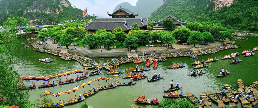 Ninh Binh Travel Guide 2026: Vietnam's UNESCO Gem (and Why Search Interest Tripled This Year) 1 Ninh Binh travel guide — sampan boats gliding through Trang An limestone karsts at dawn, UNESCO World Heritage Site Vietnam