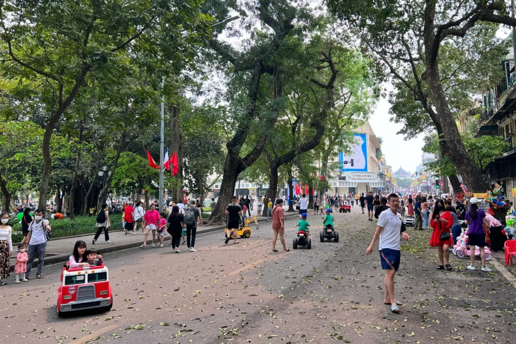 Vietnam walking tours — Hanoi Old Quarter at dawn, narrow shophouse street and street food vendors, morning mist