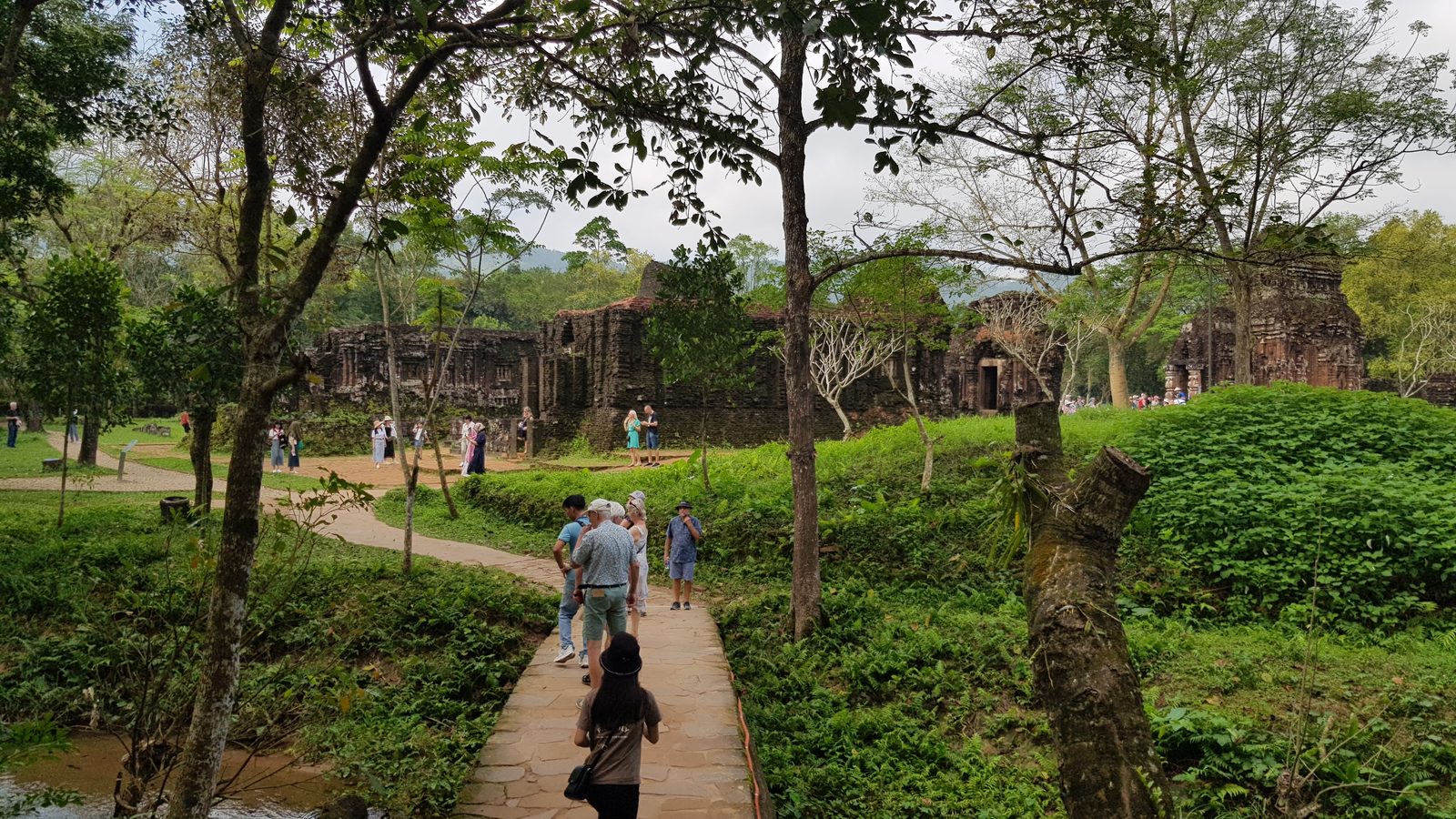 Visitors on a shaded path at My Son Sanctuary